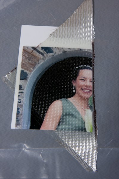 I used this mis-printed picture to make sure the resin wouldn't dissolve the printer ink. As you can see, a single ply of BID fiberglass is almost completely transparent. The imperfections are from the surface texture of the glass cloth.