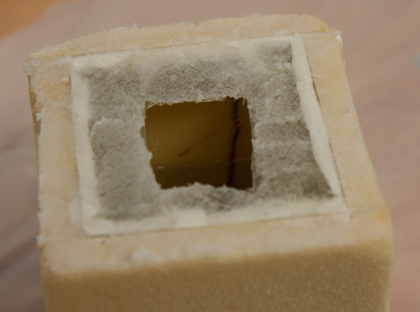For bonding, flox was added on top of the flanges before putting the lid in place. At this point, the cube is half-filled with gasoline, which is visible through the top hole.